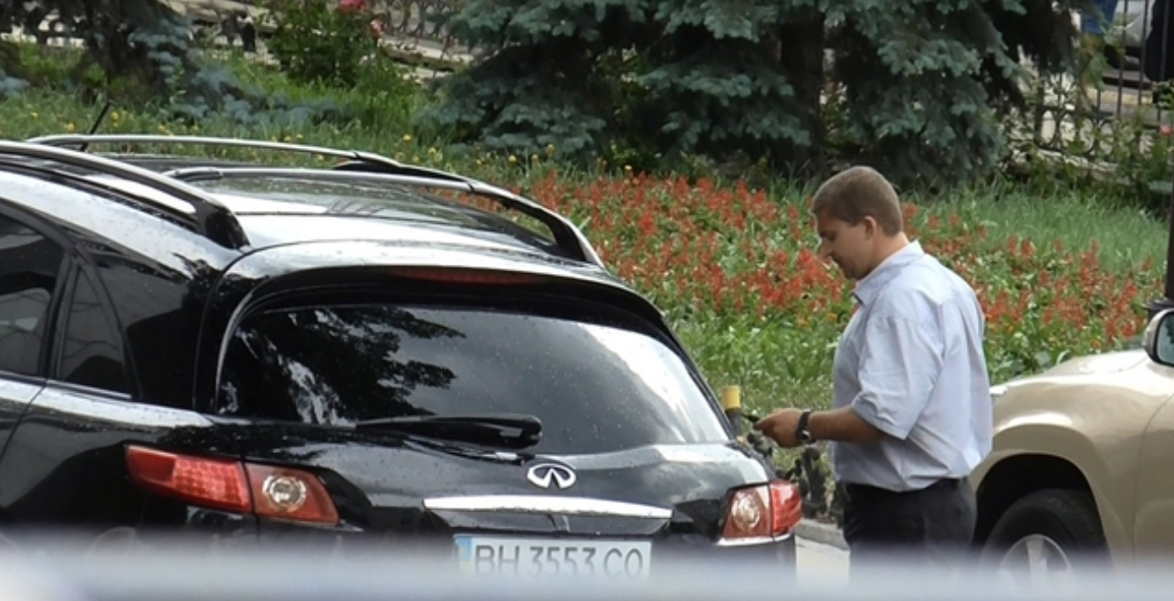 A person standing next to a car Description automatically generated with low confidence